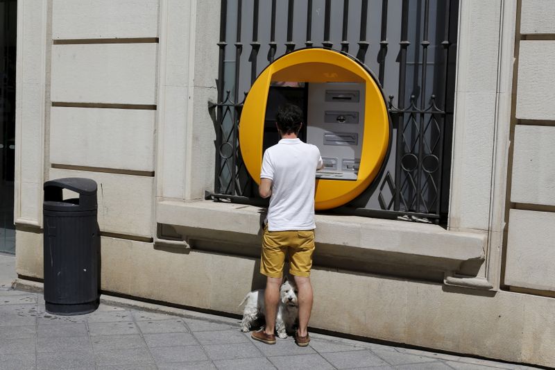 © Reuters. Cliente usa caixa eletrônico do La Caixa em Sevilha, sul da Espanha