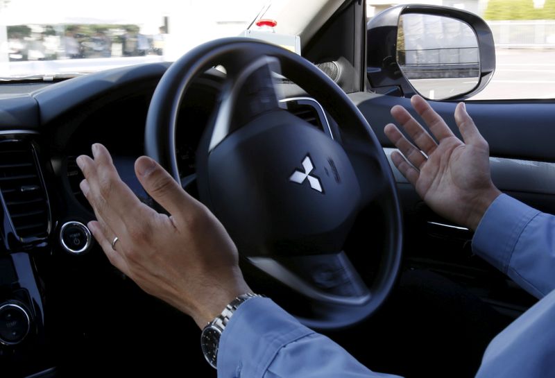 © Reuters. FILE PHOTO: A staff member of Mitsubishi Electric drives its self-driving concept car "EMIRAI3 xAUTO" using the hands-free function during a media preview in Kamakura