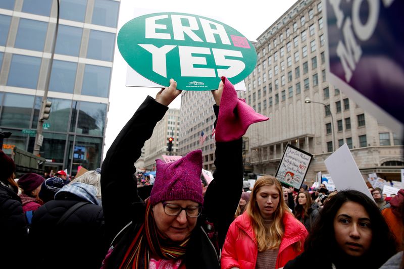 © Reuters. FILE PHOTO: A demonstrator holds a sign calling for an equal rights amendment (ERA) during in the Third Annual Women's March at Freedom Plaza in Washington