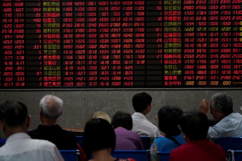 © Reuters. Investors look at an electronic board showing stock information at a brokerage house in Shanghai