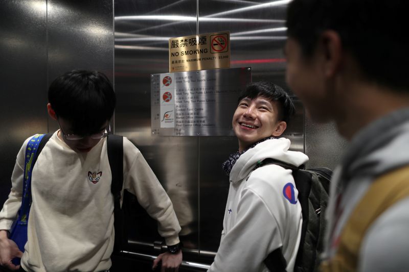 © Reuters. Student journalist Oscar Tsoi rides an elevator with friends Jeff Cheung and Ryan Cheng in Hong Kong