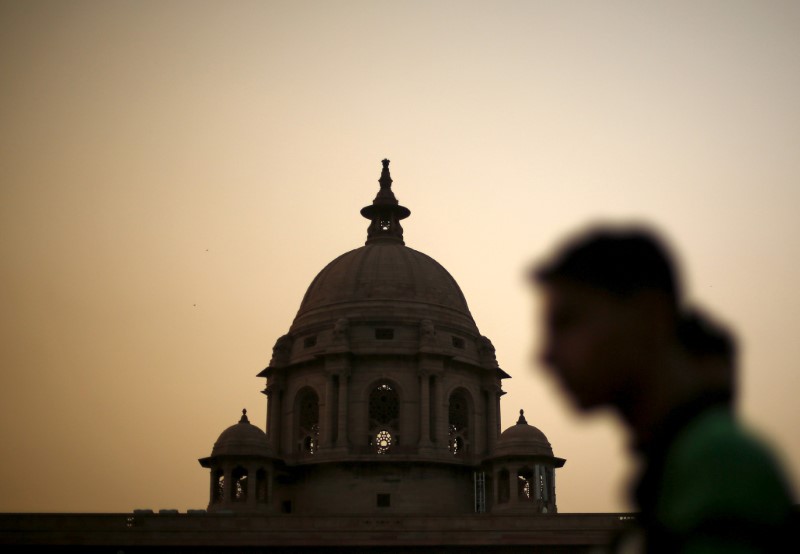 © Reuters. FILE PHOTO: A commuter walks past the building of India's Ministry of Finance during dusk in New Delhi