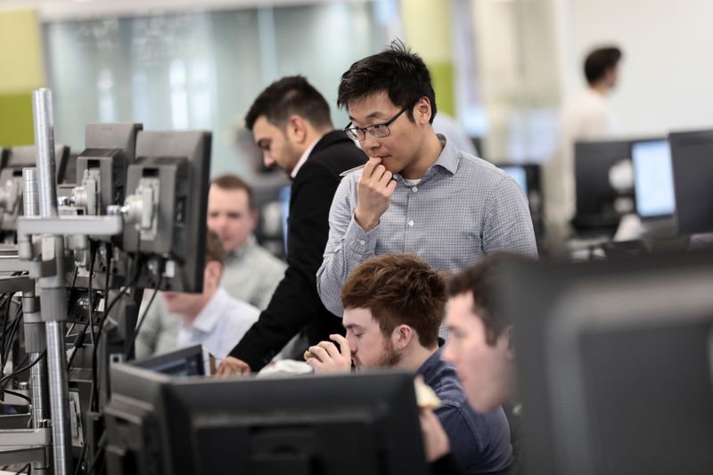 © Reuters. Traders looks at financial information on computer screens on the IG Index trading floor