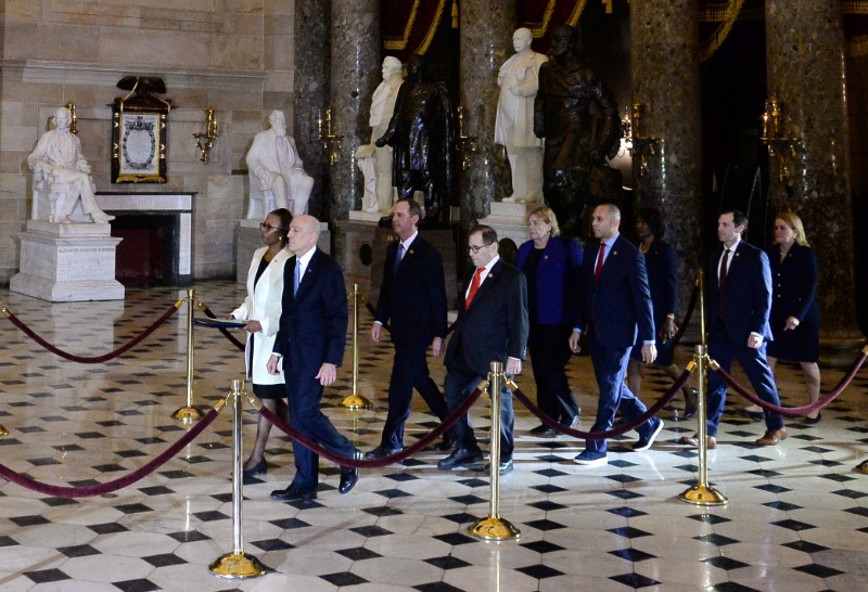 © Reuters. Secretary of the Senate Irving, House Clerk Johnson and impeachment managers walk through Statuary Hall with the articles of impeachment in the U.S. Capitol in Washington