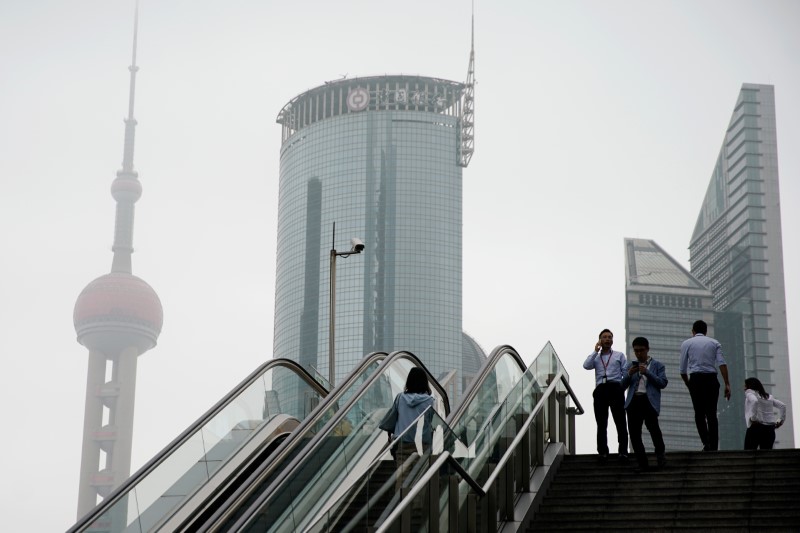 © Reuters. People walk near skyscrapers at Lujiazui financial district in Shanghai