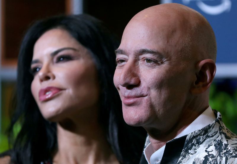 © Reuters. Jeff Bezos, founder of Amazon, and his girlfriend TV presenter Lauren Sanchez pose after arriving at a company event in Mumbai