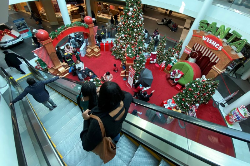 © Reuters. Families wait in line to meet Santa Claus at Fashion Centre at Pentagon City, decorated for the holidays, in Arlington, Virginia