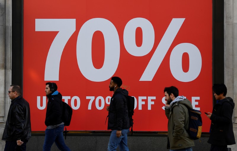 © Reuters. Pedestrians pass a sale sign on a retail shop on Oxford Street in London