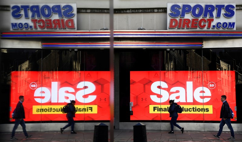 © Reuters. Pedestrians are seen reflected in a window as they pass a branch of Sports Direct on Oxford Street in London