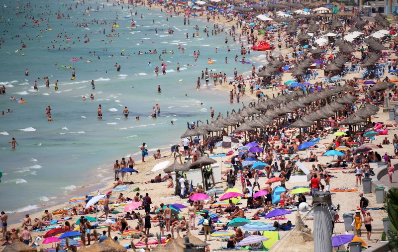 © Reuters. FILE PHOTO: Tourists sunbathe in El Arenal beach in the island of Mallorca