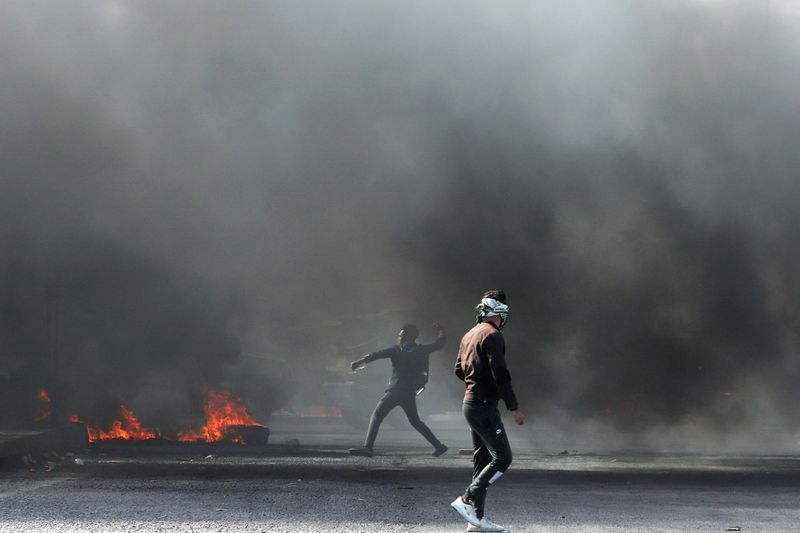 © Reuters. Iraqi demonstrators burn tires during ongoing anti-government protests in Basra