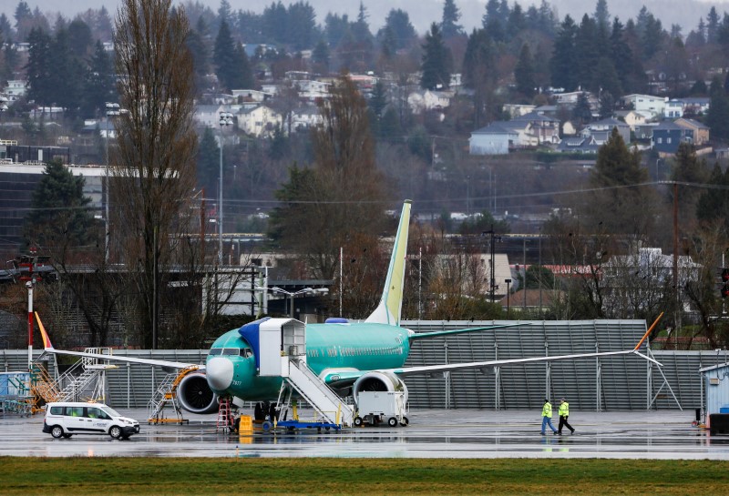 © Reuters. Employees walk near a Boeing 737 Max aircraft at the Renton Municipal Airport in Renton