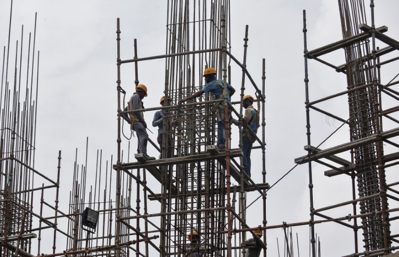 © Reuters. Workers erect scaffolding at a construction site of a metro rail station in Kolkata