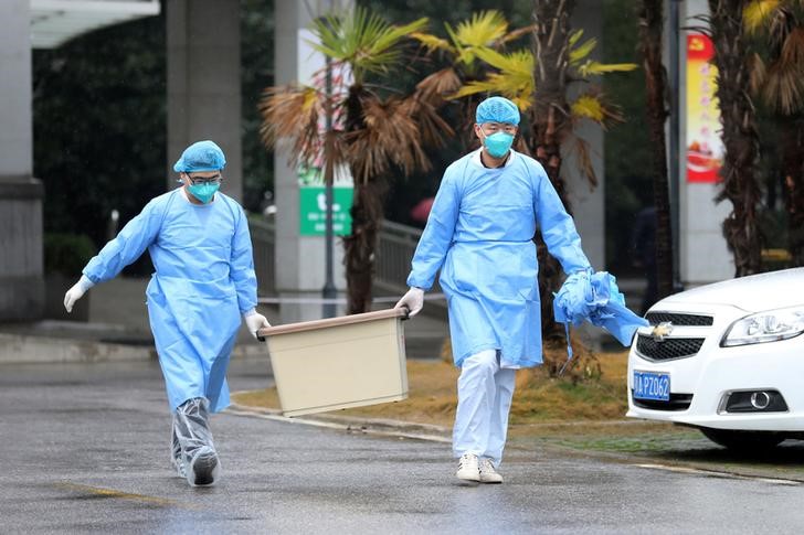 © Reuters. El equipo médico lleva una caja mientras camina hacia el hospital Jinyintan, donde hay pacientes con neumonía causada por la nueva cepa de coronavirus bajo tratamiento, en Wuhan, provincia de Hubei, China.
