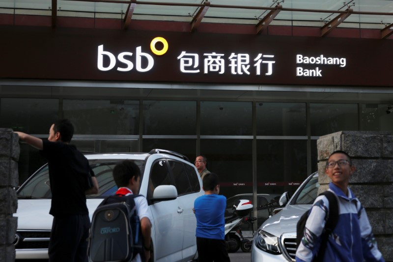 © Reuters. People walk past a branch of Baoshang Bank in Beijing