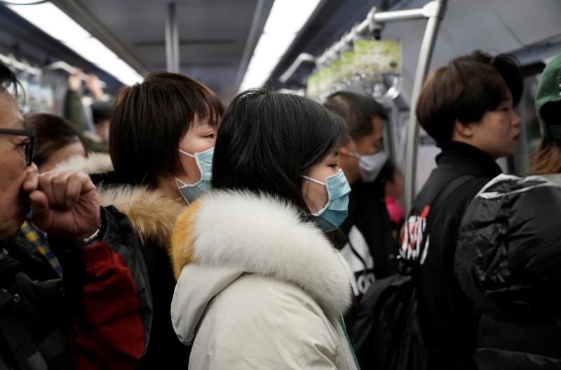 © Reuters. I passeggeri della metropolitana di Pechino, dotati di mascherine