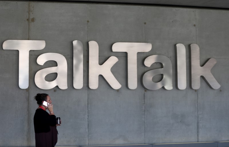 © Reuters. A woman speaks on her phone as she passes a branded logo outside the Talktalk headquarters in London
