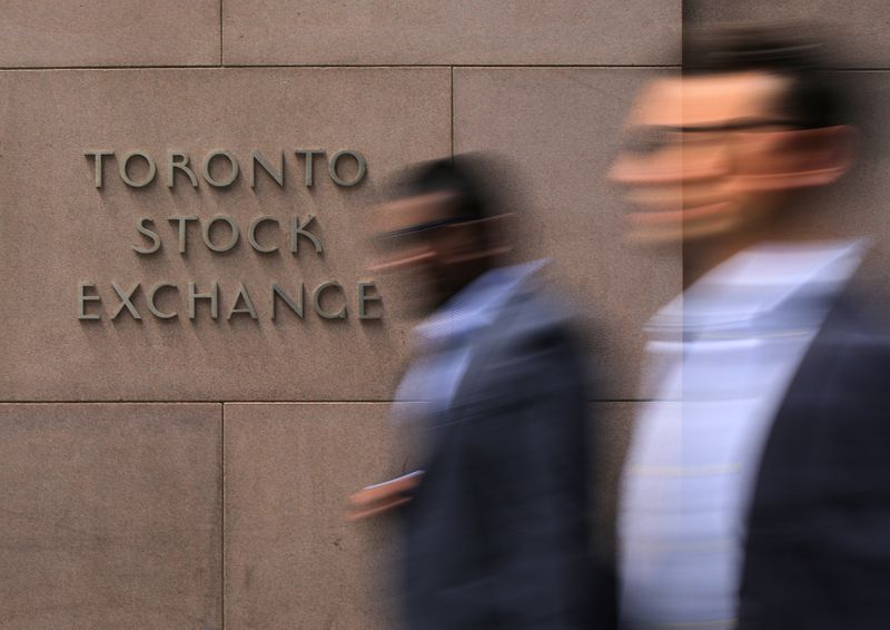 © Reuters. Businessmen pass the Toronto Stock Exchange sing in Toronto