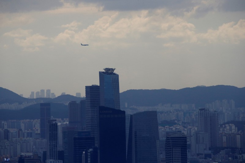 © Reuters. Un avión vuela sobre edificios comerciales en Seúl