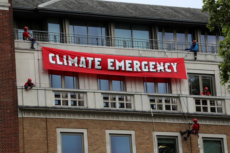 © Reuters. FILE PHOTO: Greenpeace activists hang from ropes as they unfurl a banner on the BP headquarters in London