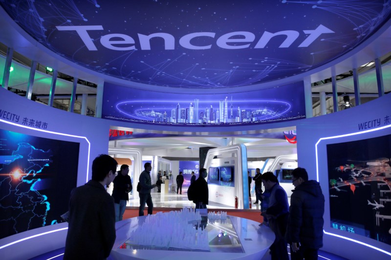 © Reuters. FILE PHOTO: People visit Tencent's booth at the World 5G Exhibition in Beijing