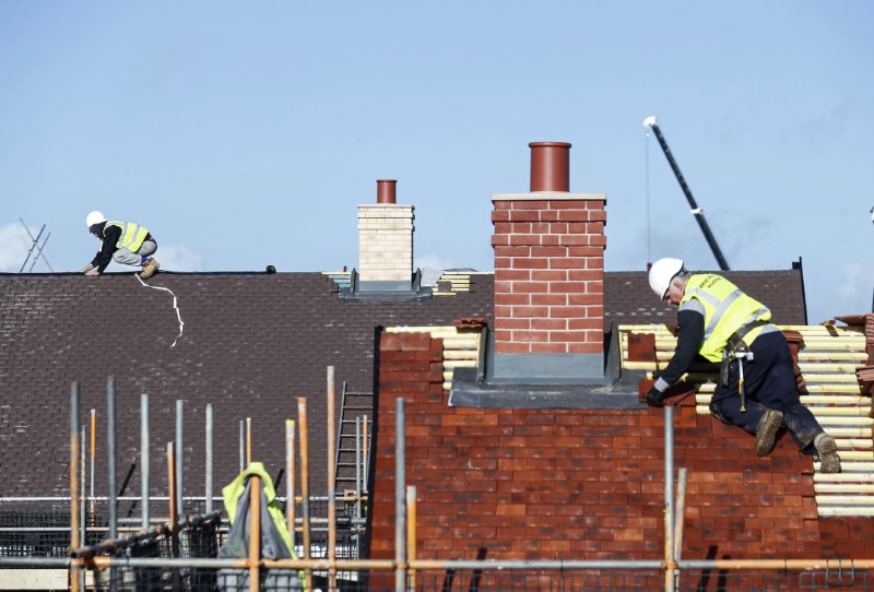 © Reuters. FILE PHOTO: Construction workers work on a Taylor Wimpey housing estate in Aylesbury
