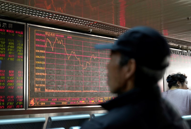 © Reuters. An investor looks at a stock quotation board at a brokerage office in Beijing