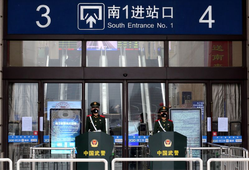 © Reuters. Chinese paramilitary officers wearing masks stand guard at an entrance of the closed Hankou Railway Station after the city was locked down following the outbreak of a new coronavirus in Wuhan