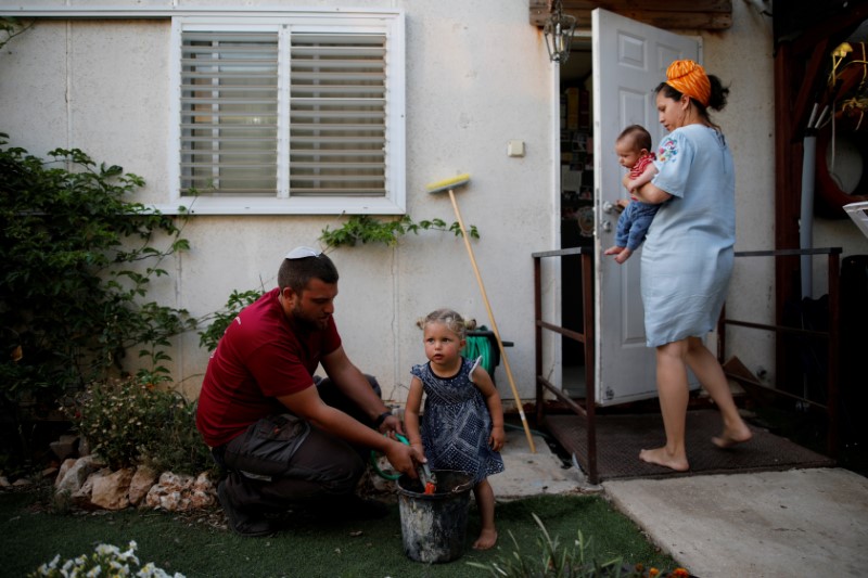 © Reuters. FILE PHOTO: An Israeli family spend time in their garden in the Israeli settlement of Ofra in the occupied West Bank