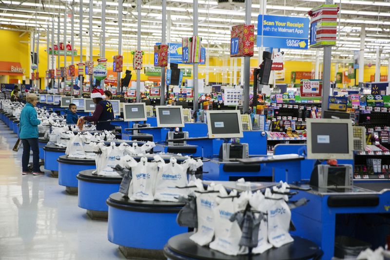 © Reuters. FILE PHOTO: Employees work at the checkout counters of a Walmart store in Secaucus, New Jersey
