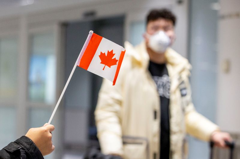 © Reuters. Travellers wearing masks arrive at Pearson airport in Toronto