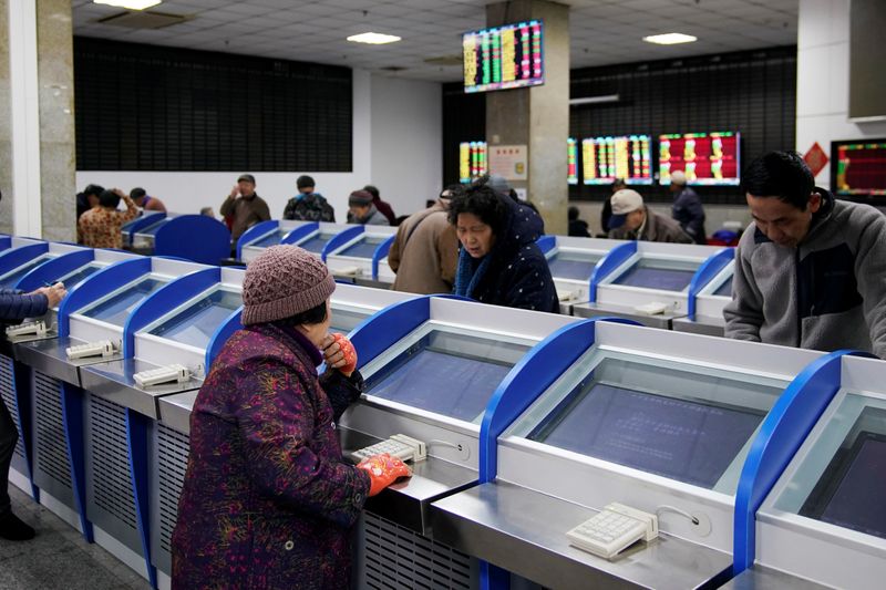 © Reuters. Investors look at computer screens showing stock information at a brokerage house in Shanghai