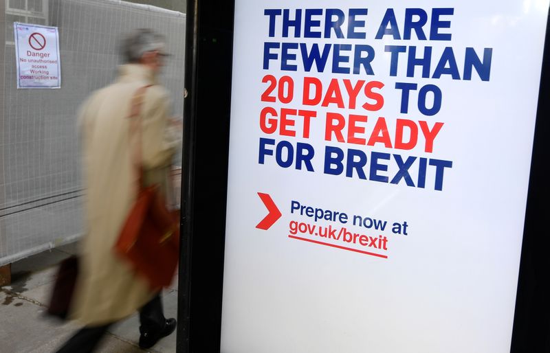 © Reuters. A man walks past an UK government Brexit information campaign poster at a bus stop in central London