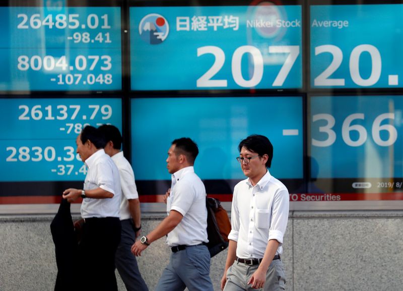© Reuters. Homem passa em frente a tela mostrando o índice japonês Nikkei em Tóquio