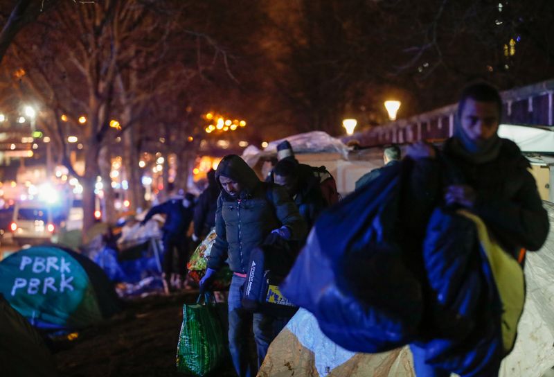 © Reuters. الشرطة الفرنسية تجلي مهاجرين من مخيم مؤقت في شمال باريس