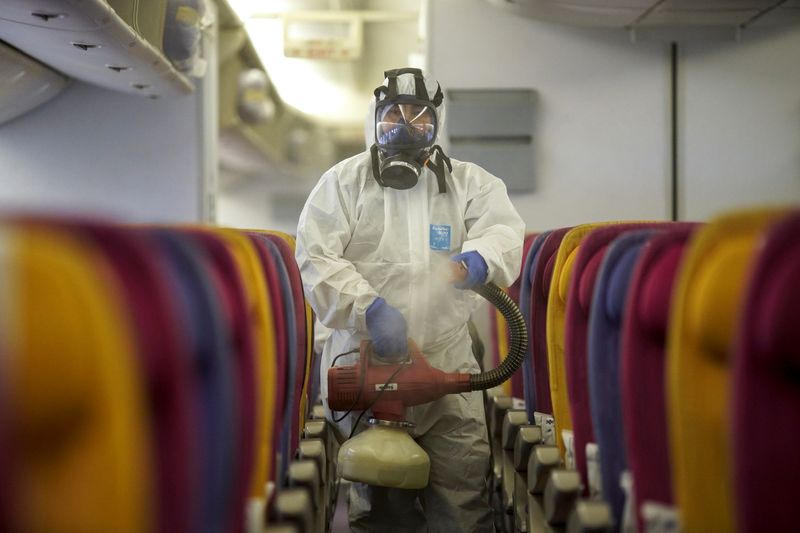 © Reuters. A member of the Thai Airways crew disinfects the cabin of an aircraft of the national carrier during a procedure to prevent the spread of the coronavirus at Bangkok's Suvarnabhumi International Airport