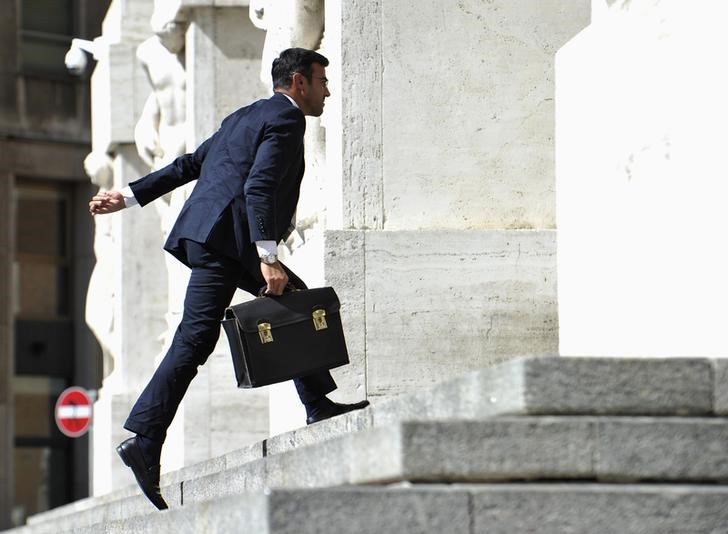 © Reuters. Un uomo sale le scale dell'ingresso della Borsa di Milano