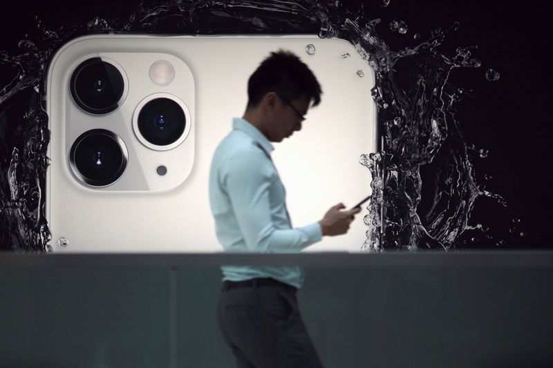 © Reuters. A man walks next to an advertisement for Apple's new iPhone 11 Pro at the Apple Store in IFC, Central district, Hong Kong, China