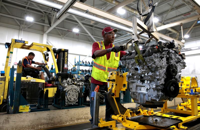 © Reuters. FILE PHOTO: A General Motors assembly worker moves a V6 engine, used in a variety of GM cars, trucks and crossovers, from the final assembly line at the GM Romulus Powertrain plant in Romulus