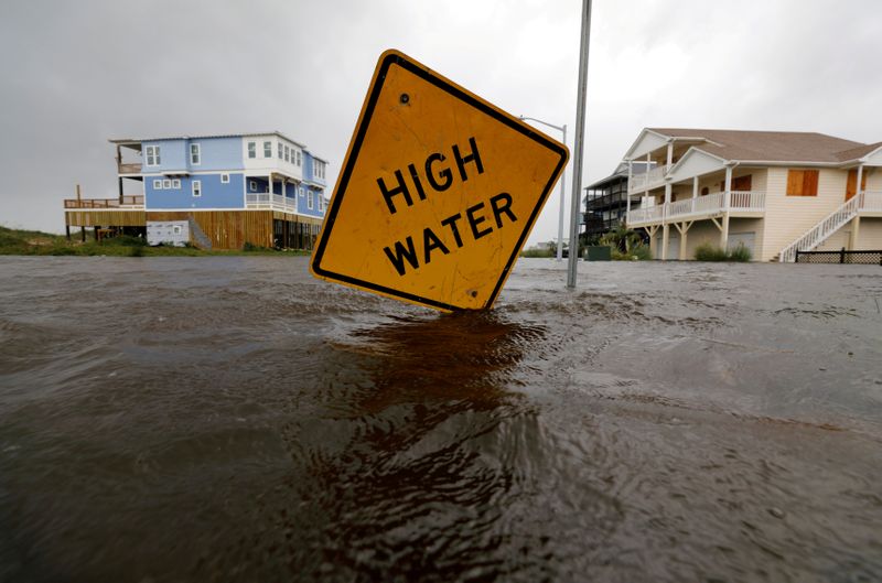 © Reuters. FILE PHOTO: Flood waters lap at a high water warning sign that was partially pushed over by Hurricane Florence on Oak Island, North Carolina