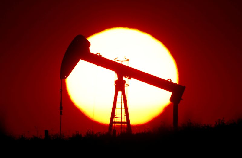 © Reuters. The sun sets behind a pump-jack outside Saint-Fiacre