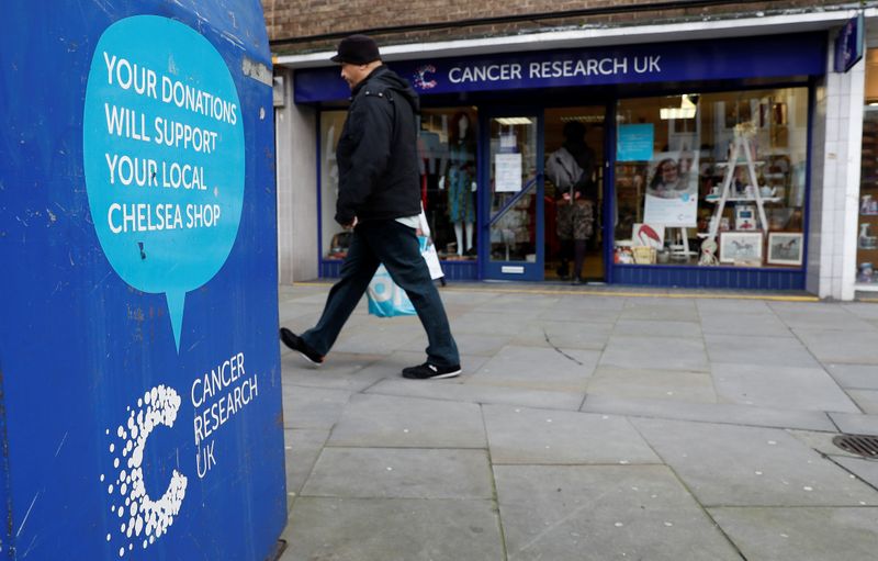 © Reuters. A man walks past a Cancer Research UK store in London