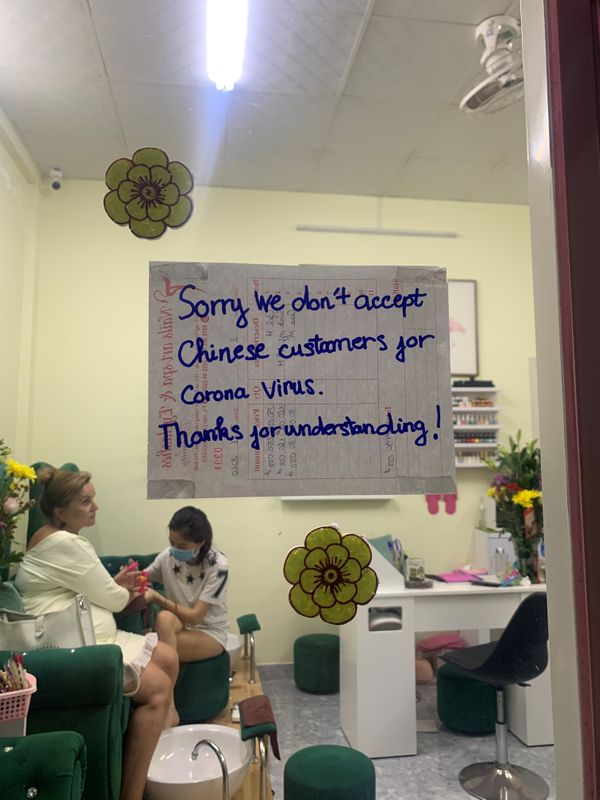 © Reuters. A sign which says the shop is not accepting Chinese customers because of the corona virus is seen on the front door of a nail bar in the island of Phu Quoc