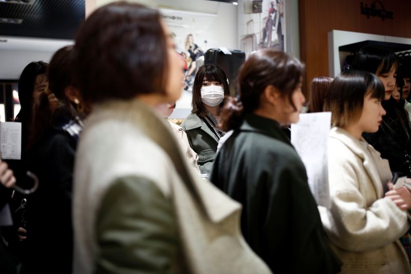 © Reuters. Tourist wears a protective mask at a duty free shop in Paris as the country is hit by the new coronavirus