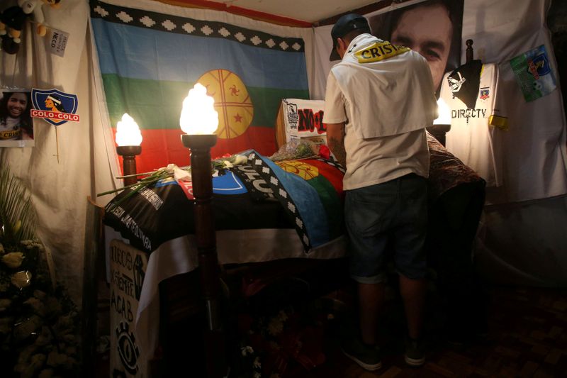 © Reuters. A relative of Mora attends his wake in Santiago