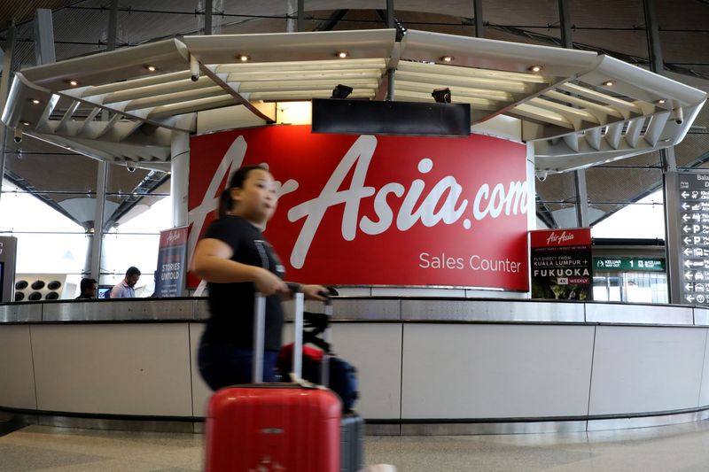© Reuters. FILE PHOTO:  A woman walks past an AirAsia counter at Kuala Lumpur International Airport in Sepang