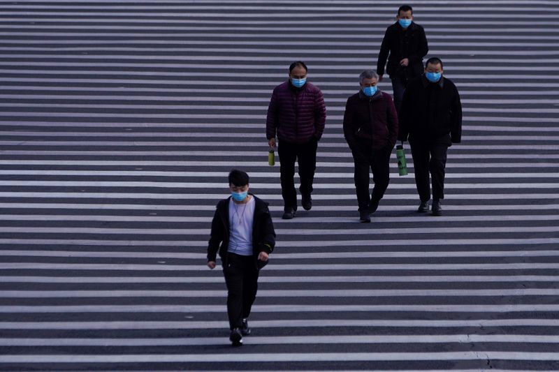 © Reuters. People wearing masks are seen at Lujiazui financial district in Pudong, Shanghai