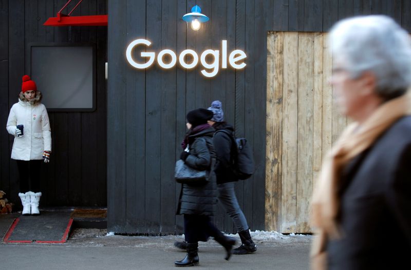 © Reuters. People walk past the logo of Google in Davos