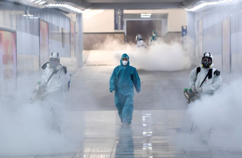 © Reuters. Volunteers in protective suits disinfect a railway station as the country is hit by an outbreak of the new coronavirus, in Changsha