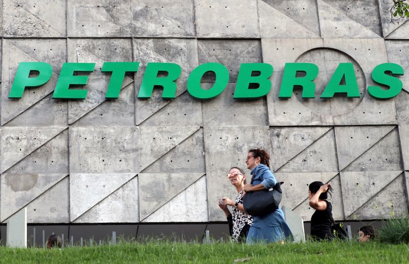 © Reuters. FILE PHOTO: People walk in front of the Brazil's state-run Petrobras oil company headquarters in Rio de Janeiro